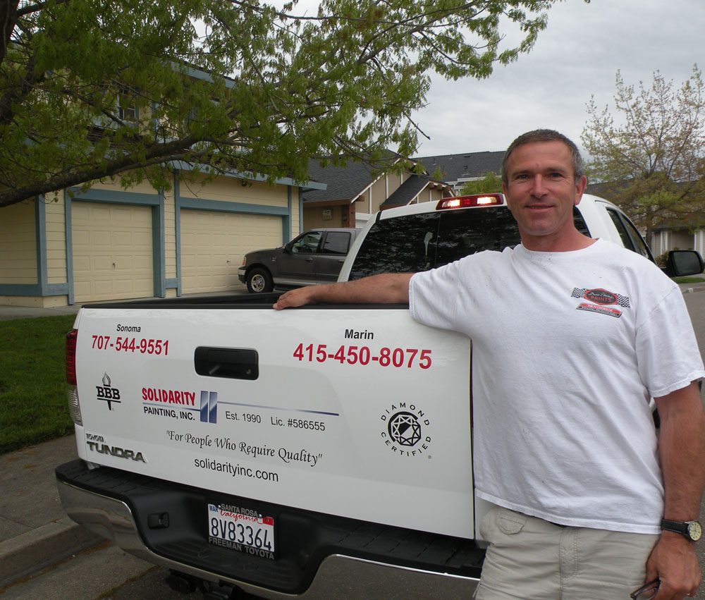 Greg Kuzmicki beside his lettered Solidarity Painting truck — Est. 1990, Lic. #586555