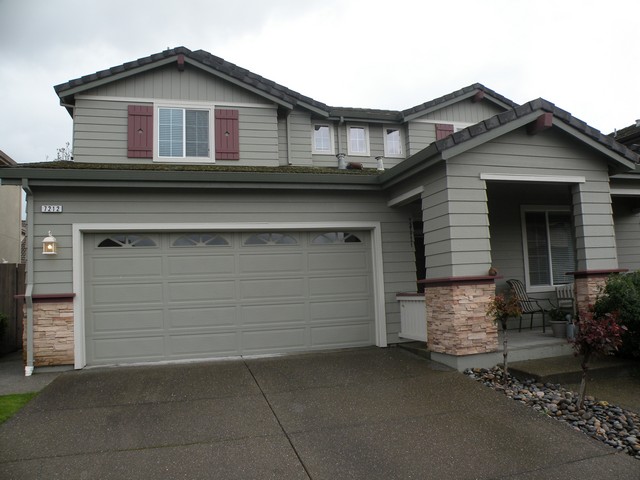 Repainted two-story home with burgundy shutters and stone accents