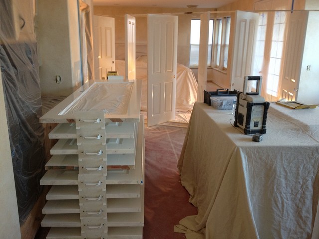 Interior fully draped and masked, with doors finished flat on a drying rack